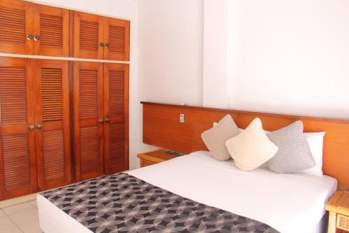 a bedroom with a large bed with wooden cabinets at The Melanesian Port Vila in Port Vila