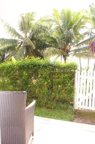 a wicker chair sitting in front of a white fence at The Melanesian Port Vila in Port Vila