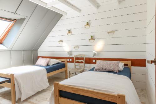Cette chambre mansardée comprend 2 lits et une fenêtre. dans l'établissement L'atelier, à La Chapelle-Saint-Martin-en-Plaine