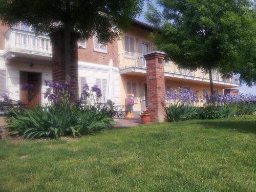 una casa con flores púrpuras delante de ella en CASA FRUSCIONE, en Magliano Alfieri