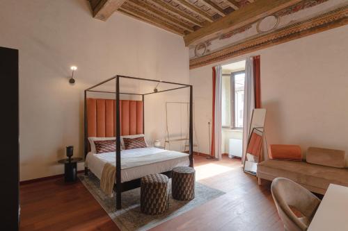 Un dormitorio con una cama con dosel y un sofá. en Torre Capranica, en Roma