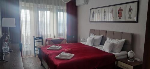 a bedroom with a red bed with towels on it at Villa Malezan in Ohrid