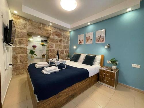 a bedroom with a large bed with a blue wall at Ha-Yabok #2 in Jerusalem