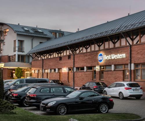 a parking lot with cars parked in front of a building at Best Western Hotel Braunschweig Seminarius in Braunschweig