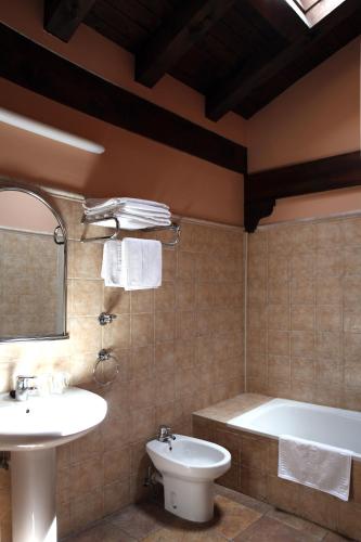 a bathroom with a tub and a sink and a toilet at Hostal Antxitonea in Elizondo