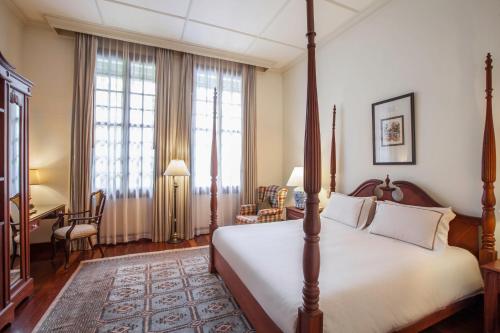 a bedroom with a bed and a desk in a room at Settha Palace Hotel in Vientiane