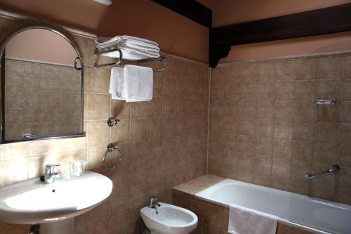 a bathroom with a sink and a tub and a toilet at Hostal Trinkete Antxitonea in Elizondo