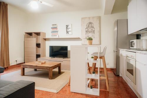 uma pequena sala de estar com uma mesa e uma cozinha em VALERIA-DREAMS Loscos em Zaragoza