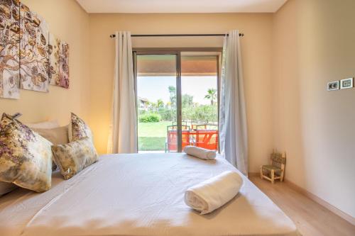 1 dormitorio con 1 cama grande y ventana grande en Appartement Pied dans l'Eau - jardin privée en Marrakech