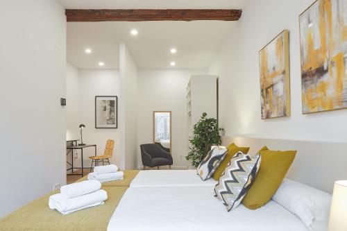 - une chambre avec un lit blanc et des oreillers dans l'établissement Autonomia - The Rentals Collection, à Saint-Sébastien