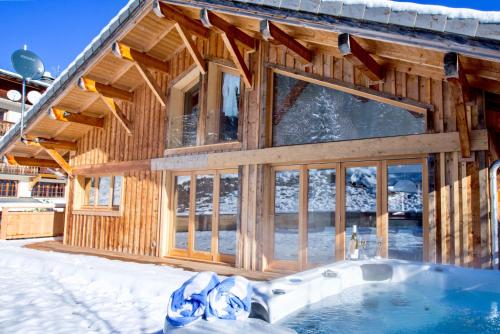 a wooden house with a swimming pool in the snow at Les Trois Bonheurs in Morzine