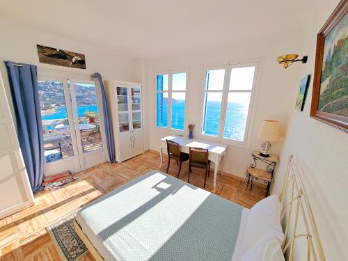 a living room with a table and some windows at Sea view studio terrasse Cap Martin/Monaco in Roquebrune-Cap-Martin