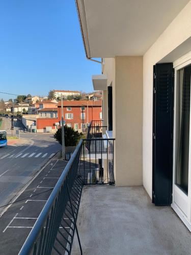 a balcony of a building with a black door at Hôtel Le Costellan in Dagneux