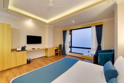 a hotel room with a bed and a flat screen tv at Yashshree Sikkim Blossom 600 Meters from MG Marg in Gangtok