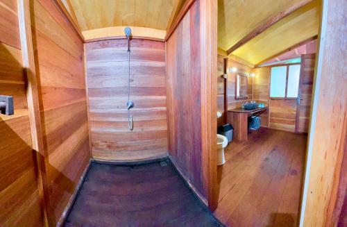 a bathroom with wooden walls and a wooden floor at Agusta Eco Resort in Pulau Mansuar