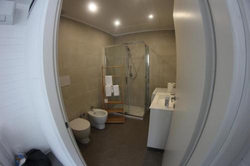 een badkamer met een douche, een toilet en een wastafel bij AURORA BEACH & SUITE in Margherita di Savoia
