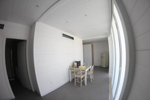 een witte kamer met een tafel en een raam bij AURORA BEACH & SUITE in Margherita di Savoia