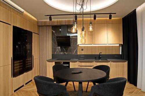 eine Küche mit einem Tisch und Stühlen sowie eine Küche mit einer Theke in der Unterkunft Mama's Design & Boutique Hotel in Bratislava