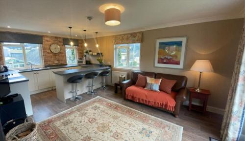 a living room with a couch and a kitchen at River View Knockraich Farm in Fintry