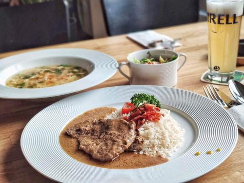 a table with a plate of food with rice and meat at Hotel Lípa in Dolní Lipová