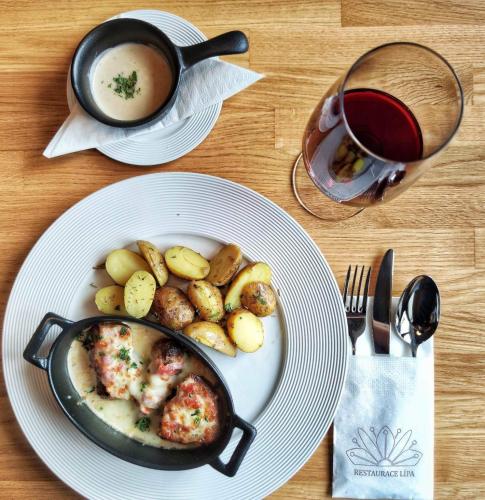 a plate of food with potatoes and a pot of soup at Hotel Lípa in Dolní Lipová