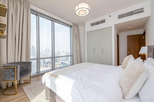ドバイにあるSpacious 3BDR Apartment and maid room with Burj Khalifa Viewのベッドルーム(白いベッド1台、大きな窓付)