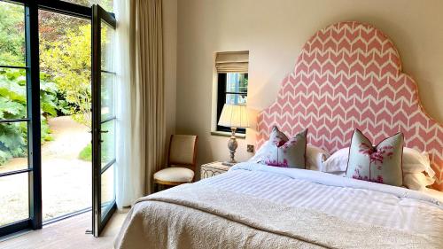 um quarto com uma cama grande e uma cabeceira vermelha e branca em Marlfield House Hotel em Gorey