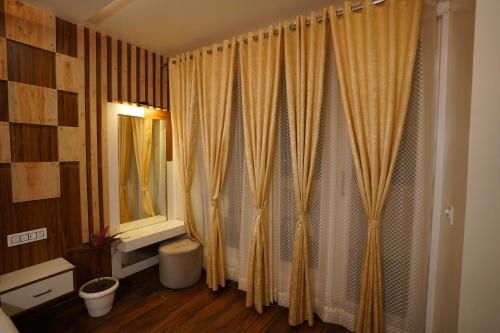 a bathroom with a yellow shower curtain and a mirror at The Royal Hotel in Haldwāni