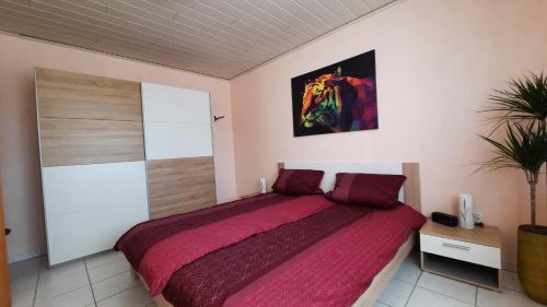 1 dormitorio con 1 cama grande con manta roja en Ferienwohnung Mia en Brüggen