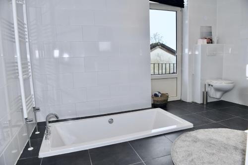 a white bath tub in a bathroom with a toilet at Villa Aix in Kerkrade