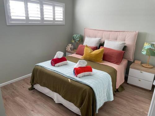 a bedroom with a large bed with pillows on it at Lil Sass in Mudjimba