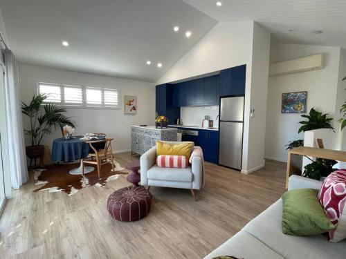 a living room with blue cabinets and a kitchen at Lil Sass in Mudjimba