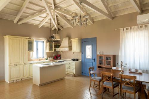 a kitchen with a table and a dining room at VILLA HORIZON, PORTIANOU in Pedhinón