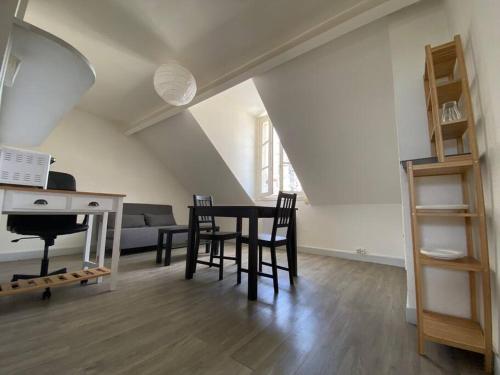 - un salon avec une table, des chaises et un piano dans l'établissement Orléans Centre Historique - Bourgogne/Cathédrale, à Orléans