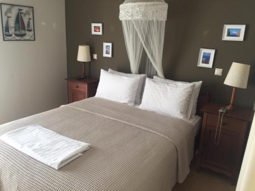 a bedroom with a bed with white sheets and pillows at VILLA HORIZON, PORTIANOU in Pedhinón