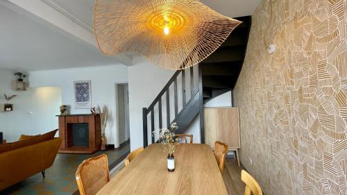 une salle à manger avec une table et un grand éclairage dans l'établissement Jolie maison à 2 pas de la forêt du Touquet, à Cucq