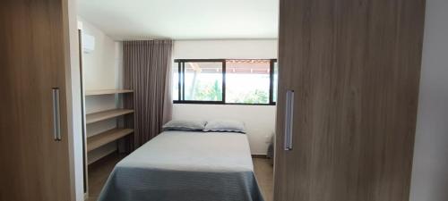 een kleine slaapkamer met een bed en een raam bij Maui Beach Residence, 3 quartos, Tamandaré PE in Tamandaré