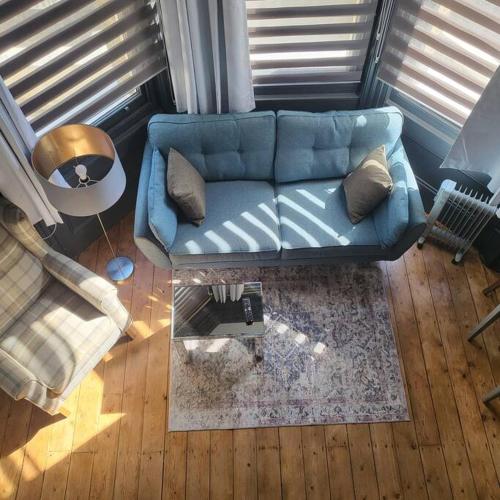 a living room with a blue couch and a table at 21 Mini Loft Apartment - Great Location - Comfy King Size Bed in Brighton & Hove