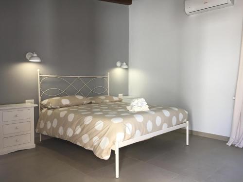 a bedroom with a bed and a dresser in it at Azienda agricola Crilù in Milazzo
