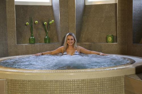 a woman is sitting in a bath tub at Hotel Lípa in Dolní Lipová