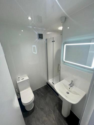 a white bathroom with a toilet and a sink at Top Twenty Bed and Breakfast in Windsor