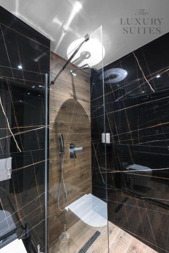 a bathroom with a shower with a glass door at Adelle Apartments, The Luxury Suites in Thessaloniki