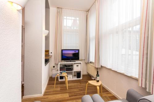 ein Wohnzimmer mit einem Sofa und einem TV in der Unterkunft Villa Anna - Rubin in Bansin
