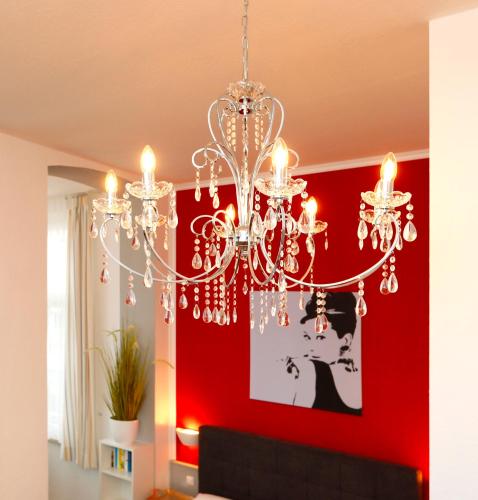 einen Kronleuchter im Wohnzimmer mit einer roten Wand in der Unterkunft Villa Anna - Rubin in Bansin