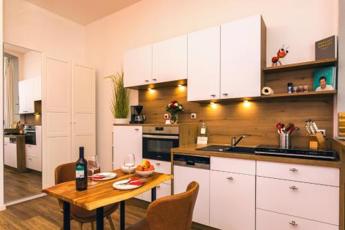 eine Küche mit weißen Schränken und einem Tisch mit einer Flasche Wein in der Unterkunft Villa Anna - Rubin in Bansin