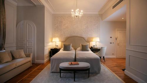 a bedroom with two beds and a couch and a chandelier at Amadria Park Hotel Sveti Jakov in Opatija