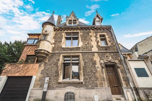 un vieux bâtiment avec une tourelle dans une rue dans l'établissement Tournelles VUE CATHEDRALE- Maison Climatisée du XVIe siècle classée, à Reims