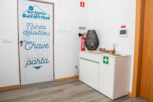 a room with a white door and a refrigerator at O Cardanho dos Galfarritos - A Casa dos Miúdos in Aveiro