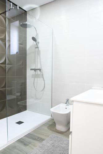 a bathroom with a shower and a toilet and a sink at O Cardanho dos Galfarritos - A Casa dos Miúdos in Aveiro