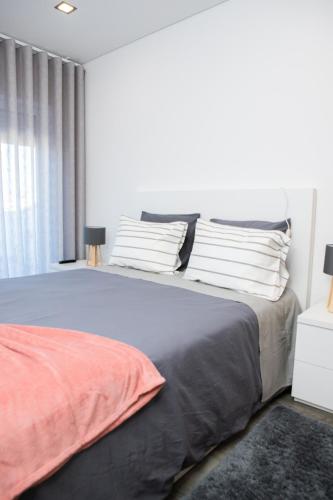 a bedroom with a large bed and a window at O Cardanho dos Galfarritos - A Casa dos Miúdos in Aveiro